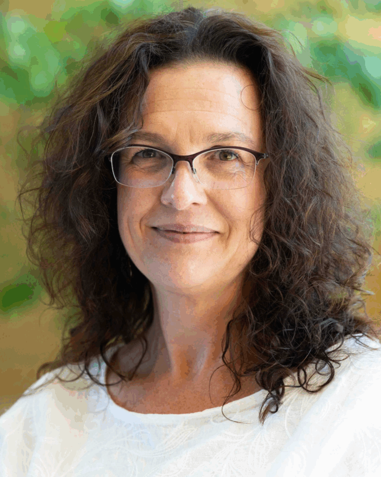 Headshot of a woman with brown hair and glasses.