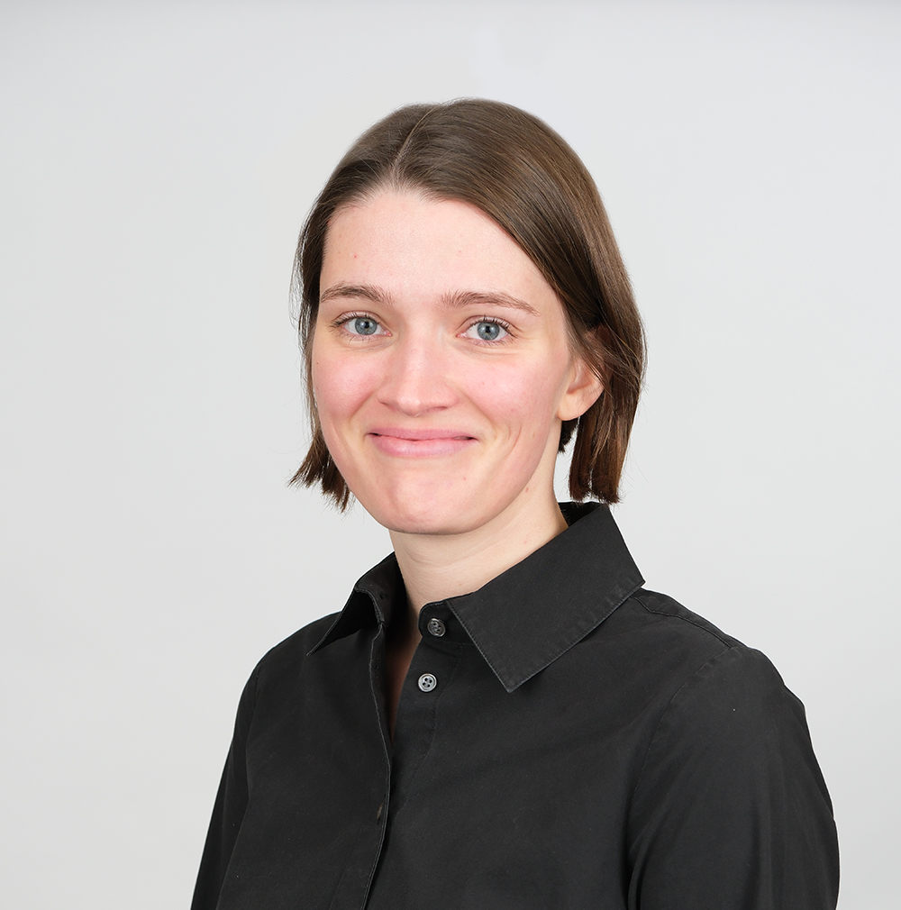 A headshot of a woman wearing a black button up shirt.