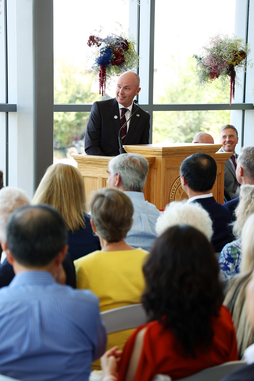 A man stands at a podium in front of a crowd.