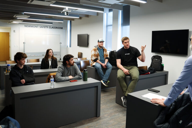 A group of students discuss while sitting on guests.