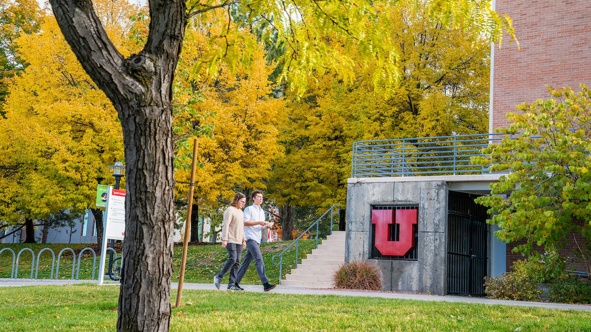 View of the university of Utah business building in the fall, with a prominent "Block U", a red capital U in block letter style.
