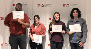 Four people stand in front of a Wilkes Center branded banner. Left to right, man woman woman man.